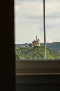 una ventana con vistas a un castillo en una colina en Magaré Hotel & Restaurant en Lahnstein