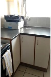 a kitchen with white cabinets and a counter top at Ross Height Unit 16 in Richards Bay