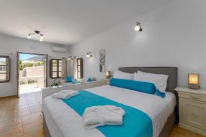 a bedroom with a large bed with towels on it at En Plo Boutique Suites in Oia