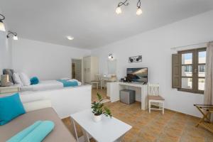 a living room with a couch and a tv at En Plo Boutique Suites in Oia