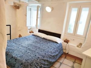 ein Schlafzimmer mit einem Bett und zwei Fenstern in der Unterkunft CÁNTARO. Las Puertitas Rojas in Ubrique
