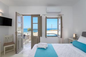 a bedroom with a bed and a view of the ocean at En Plo Boutique Suites in Oia +37 photos