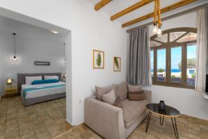 a living room with a couch and a bed at En Plo Boutique Suites in Oia