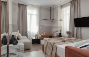 una camera d'albergo con due letti e un divano di Luxury Suites by Lato ad Ágios Nikólaos