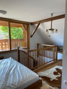 a bedroom with a bed and a staircase with windows at Pr Krač Countryside Hideaway in Dol pri Ljubljani