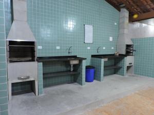 a green tiled kitchen with two sinks and a stove at Condomínio Vilalba in Ubatuba