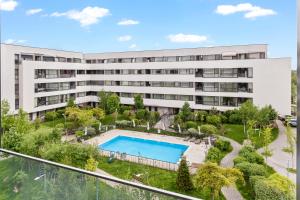 an external view of a building with a swimming pool at Atria Urban Gateway, 2BR Condo + Pool in Bucharest