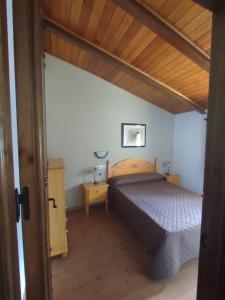 1 dormitorio con cama y techo de madera en Casa Enry, en Alcalá de la Selva