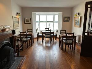 una sala da pranzo con tavoli, sedie e una finestra di Eldon's Bed & Breakfast a Roundstone