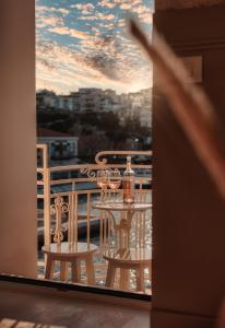 a balcony with a table with wine glasses on it at Luxury Suites by Lato in Agios Nikolaos