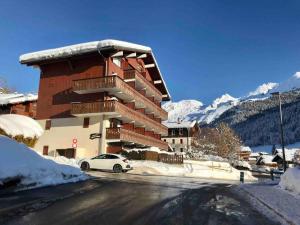 a snow covered building with a car parked in front of it at Studio 2/4 personnes - Centre village in La Clusaz