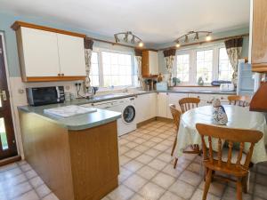 a kitchen with a table and a dining room at Llwyn Celyn in Pwllheli
