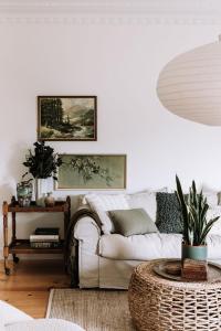 ein Wohnzimmer mit einem weißen Sofa und einem Tisch in der Unterkunft Miss Boulevard - Stylish Art Deco Villa in Shepparton