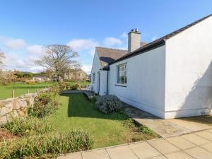una casa bianca con un cortile accanto di Llwyn Celyn a Pwllheli