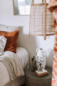 ein Schlafzimmer mit einem Bett und einem Tisch mit einer Lampe in der Unterkunft Miss Boulevard - Stylish Art Deco Villa in Shepparton