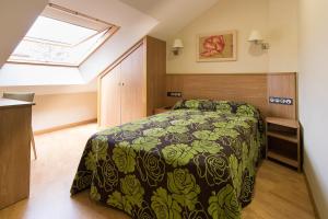 um quarto com uma cama com um cobertor preto e verde em Pontus Veteris em Sanxenxo