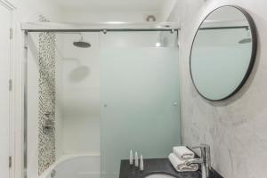 y baño con lavabo, espejo y bañera. en Stylish 2BR in Miraflores, en Lima