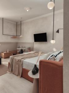 a bedroom with a bed and a tv on the wall at Luxury Suites by Lato in Agios Nikolaos