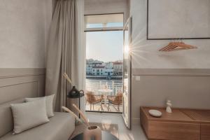 un soggiorno con un divano e una grande finestra di Luxury Suites by Lato ad Ágios Nikólaos