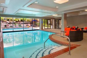 a large swimming pool with orange chairs and an indoor pool at Marriott St. Louis Airport in Edmundson