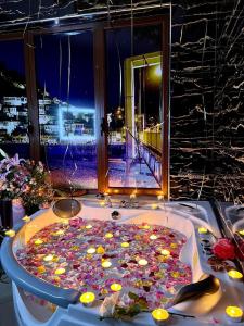 a bath tub filled with flowers and candles in front of a window at Hotel Vila Mimani in Berat