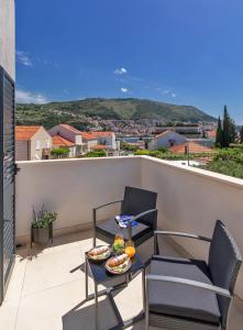 un balcone con 2 sedie e un tavolo con cibo sopra di Luxury Apartment N&P a Dubrovnik