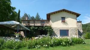 a stone house with a garden in front of it at Villa la felce in Cetona