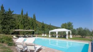 a swimming pool with chairs and a gazebo at Villa la felce in Cetona