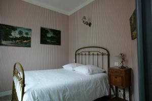 a bedroom with a white bed and a wooden nightstand at Hôtel-Restaurant Le Parisien in Les Vignes +18 photos