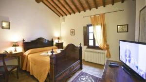 a bedroom with a bed and a flat screen tv at Il tinaio in Monteroni dʼArbia