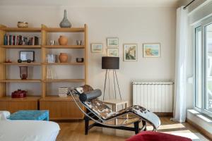 a living room with a chair and a book shelf at The Flat in Ericeira +48 photos