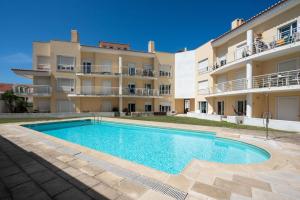 a villa with a swimming pool in front of a building at The Flat in Ericeira