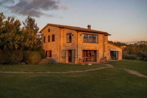 una gran casa de ladrillo en un campo de hierba en Moraio, en Collazzone