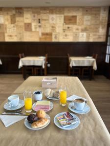 uma mesa com pratos de comida e chávenas de sumo de laranja em Residencial Dona Teresa em Maia