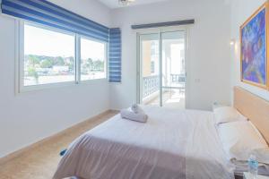 een slaapkamer met een wit bed en een groot raam bij Appartement calme au bord de la mer in Tanger