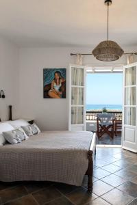 a bedroom with a bed and a view of the ocean at Sea Lilies Suites in Plaka