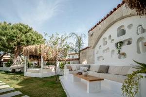 a living room with a white couch and a table at Sandal Alaçatı - Adult Only in Alacati