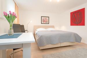 a bedroom with a bed and a table with a vase of flowers at Haus Eva Mar am Meer Appartement 5 in Timmendorfer Strand