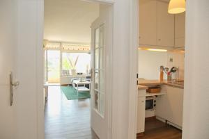 cocina con armarios blancos y comedor en Kaiserhof App 213 inkl WLAN, en Grömitz 9 fotos más