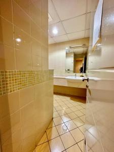 a bathroom with a sink and a refrigerator at M02 Centre Residance Near Metro in Dubai