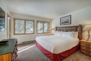 a bedroom with a bed and a desk and windows at Townsend Place in Beaver Creek