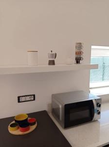 uma cozinha com um micro-ondas e três tigelas num balcão em Casa N.2 + piscina e palestra [1O km da Gallipoli] em Tuglie