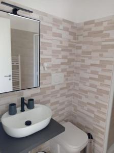 ein Badezimmer mit einem weißen Waschbecken und einem WC in der Unterkunft Casa N.2 + piscina e palestra [1O km da Gallipoli] in Tuglie