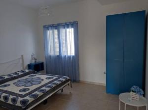 um quarto com uma cama e um armário azul em Casa N.2 + piscina e palestra [1O km da Gallipoli] em Tuglie