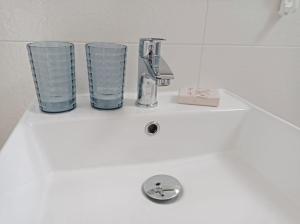 um lavatório de casa de banho com dois copos e uma torneira em Casa N.2 + piscina e palestra [1O km da Gallipoli] em Tuglie