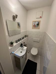 bagno con servizi igienici bianchi e lavandino di FHV01 - Ferienwohnung 100m² 6 Personen Garten und Terrasse 2x WC a Taucha