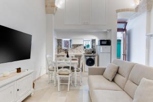 a white living room with a couch and a table at Suite L' Alcova in Fasano