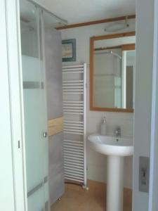 ein weißes Badezimmer mit Waschbecken und Spiegel in der Unterkunft Doxa's place in Iraklio