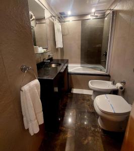 uma casa de banho com um lavatório, um WC e uma banheira em Sarmiento Palace Hotel em Buenos Aires