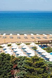 ein Strand mit Sonnenschirmen und Stühlen und das Meer in der Unterkunft Doxa's place in Iraklio